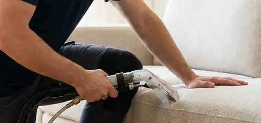 Professional upholstery cleaner deep-cleaning a fabric sofa with a handheld extraction tool, San Jose, CA.